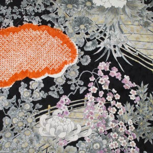 May include: A black fabric featuring a detailed floral pattern with grey and white chrysanthemums, pink cherry blossoms, and a prominent orange cloud-shaped motif with a white textured border. Gold accents highlight the floral and bridge elements.