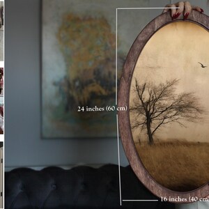 May include: A framed oval print of a lone tree in a field with a muted brown and gold colour scheme. The print is 40 cm by 60 cm and is framed in a dark wood frame.