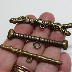 May include: A white ceramic mug with a black handle and the text "But First, Coffee" in a bold, black font. The mug is set against a blurred background, suggesting a cozy setting.