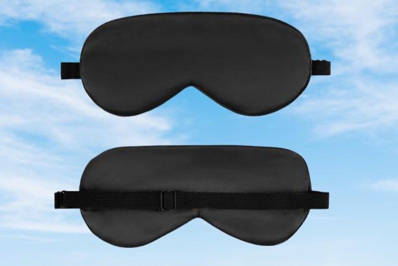 May include: A black sleep mask with an adjustable strap. The mask is made of a soft, comfortable material and is designed to block out light.