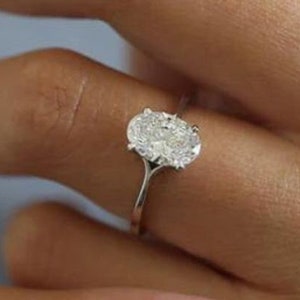 Puede incluir: Un anillo de plata con un gran diamante de forma ovalada.
