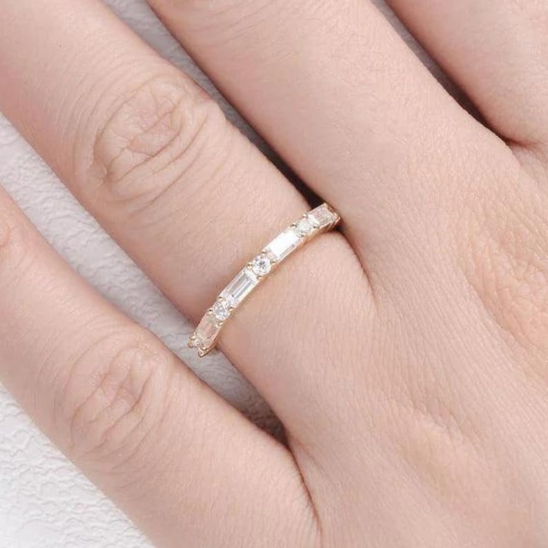 May include: A gold band ring with a row of baguette and round diamonds.