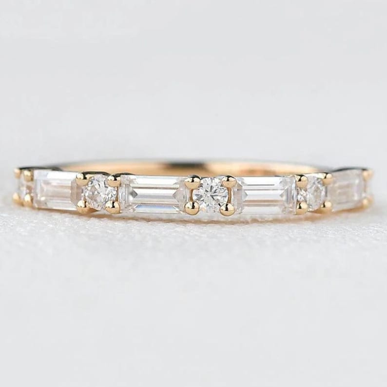 May include: A delicate gold band ring with a row of small round and baguette-shaped diamonds.