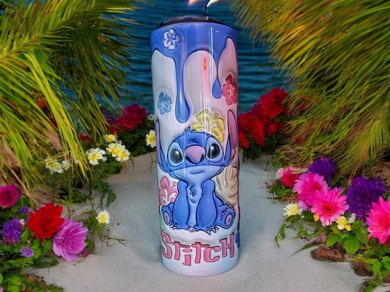 May include: A blue and white stainless steel tumbler with a cartoon image of Stitch from Lilo & Stitch. The tumbler has a dripping paint design and says "Stitch" at the bottom.