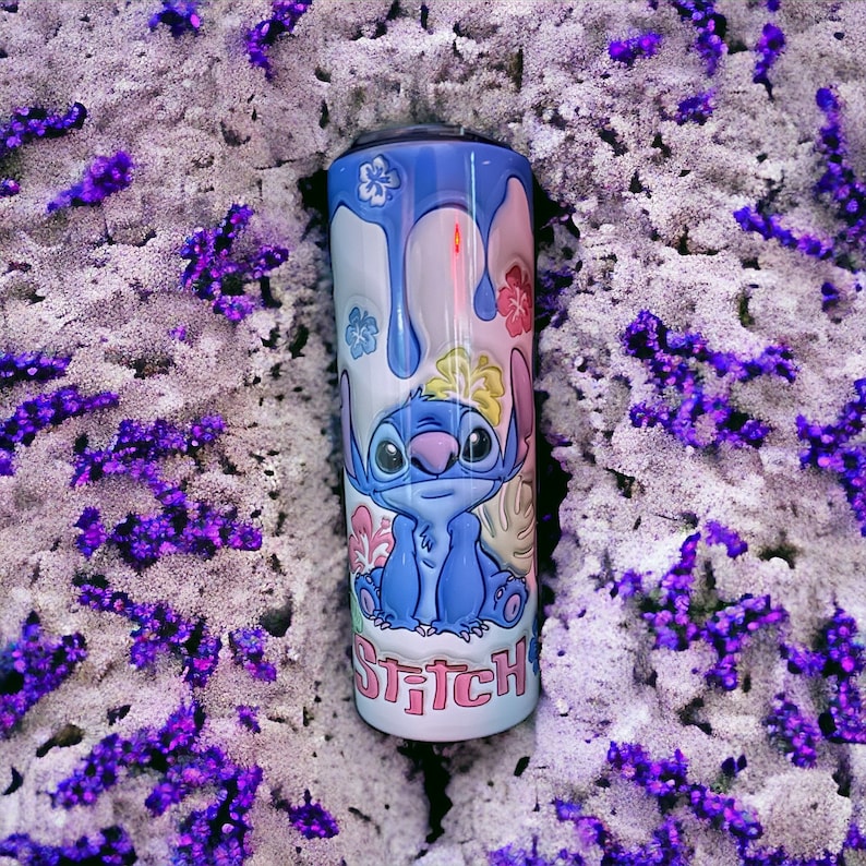 May include: A blue and white stainless steel tumbler with a cartoon image of Stitch from Lilo & Stitch. The tumbler has a blue drip design and the words "Stitch" in pink letters.