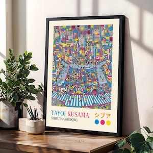 May include: A framed art print of Yayoi Kusama's Shibuya Crossing illustration. The artwork shows a bustling cityscape with people crossing the street, rendered in bright colours. The print includes the artist's name and location in English and Japanese.