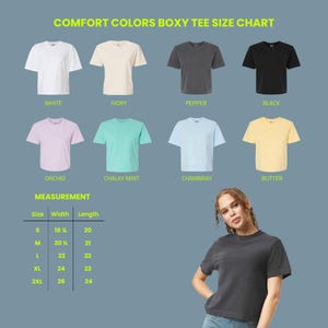 May include: A Comfort Colors boxy tee size chart displaying eight t-shirts in white, ivory, pepper, black, orchid, chalky mint, chambray, and butter. A measurement table lists sizes S through 2XL with width and length in inches. A model wears a pepper tee.