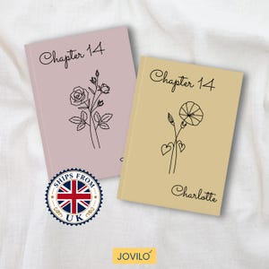 Può includere: Due quaderni con disegni floreali a tratto. Uno è rosa chiaro con un disegno di rosa, l'altro è beige con un disegno di fiore e cuore. Entrambi hanno "Chapter 14" scritto in alto. Il quaderno beige ha il nome "Charlotte" in basso.
