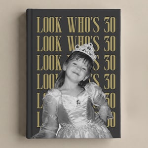 May include: A hardcover book with a dark gray cover featuring the repeating gold text LOOK WHO'S 30. The center displays a black and white photograph of a young child wearing a princess dress and a tiara, smiling while posing with hands on hips.