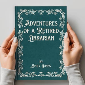 May include: A teal hardcover book titled Adventures of a Retired Librarian by Emily Jones. The cover features white text and a decorative white floral border frame. The book is held upright, displaying the front cover design clearly.