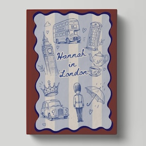 May include: A rectangular book cover with a dark red border and a light blue and white striped center. The cover features blue line drawings of a double-decker bus, telephone booth, Big Ben, crown, taxi, guard, and tea set with the text Hannah in London.