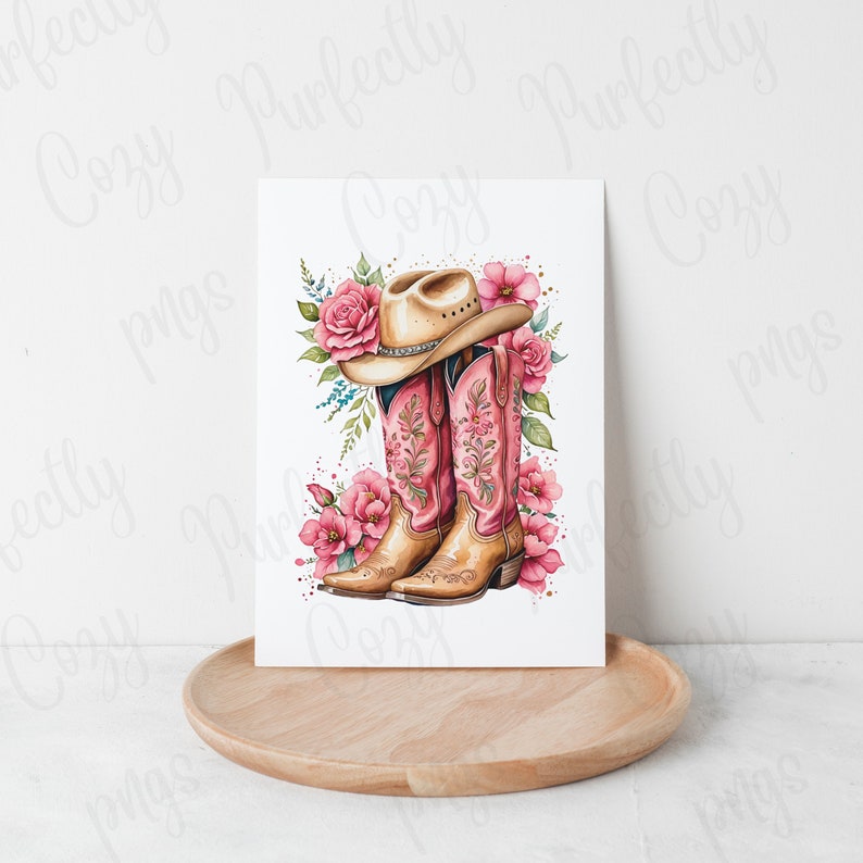 K&ouml;nnte beinhalten: Ein Paar rosa Cowboy-Stiefel mit Blumenstickerei und ein brauner Cowboyhut mit Blumenmuster. Die Stiefel und der Hut sind von rosa Blumen umgeben.