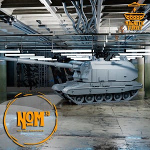 Puede incluir: Un modelo gris impreso en 3D de un obús autopropulsado con un cañón largo y una torreta giratoria. El modelo está sentado en un suelo de hormigón con un logotipo que dice "NOM 3D NOT ONLY MINIATURES" en naranja. El texto "MAGNETIC TURRET" es visible en la esquina superior derecha de la imagen.