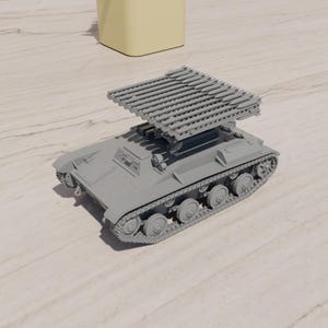 Op de afbeelding: Een grijs model van een militair voertuig met meerdere raketwerpers. Het voertuig heeft een rupsbandontwerp met meerdere wielen en een rechthoekige carrosserie. De raketwerpers zijn in een rasterpatroon op de bovenkant geplaatst.