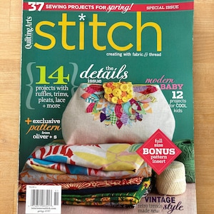 May include: The cover of a sewing magazine, "stitch", features a beige bag with colorful fabric embellishments and yellow buttons. The magazine cover is green with text that reads "37 sewing projects for spring!" and "14 details issue". A stack of fabric and thread are also visible.