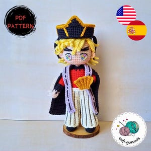 May include: A handmade crochet doll of a character with blonde hair, wearing a black and gold crown, a red shirt, and white and black striped pants. The doll has a black cape and a fan. The image includes the text "PDF PATTERN".