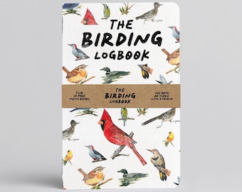 Puede incluir: Un cuaderno blanco titulado THE BIRDING LOGBOOK con coloridas ilustraciones en acuarela de varias especies de aves. Una banda de papel marrón envuelve el centro con el texto THE BIRDING LOGBOOK, TWO 20 PAGE MEMO BOOKS, USE BOTH OR SHARE WITH A FRIEND.
