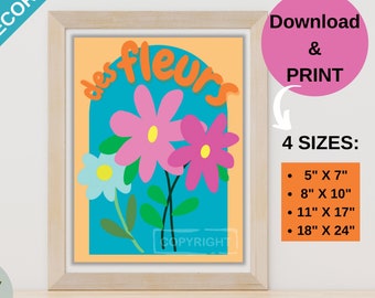 May include: A framed print with a peach background and a blue archway with the text "des fleurs" in orange. The archway is decorated with three flowers: a pink flower with a yellow centre, a light blue flower with a yellow centre, and a pink flower with a yellow centre. The print is available in four sizes: 5x7 inches, 8x10 inches, 11x17 inches, and 18x24 inches.