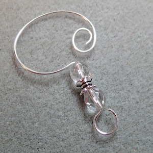 May include: Silver ornament hook with a clear crystal bead and a silver loop at the end.