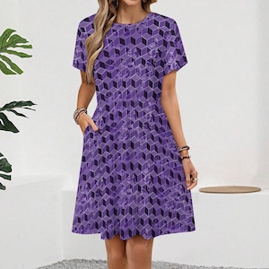 May include: A purple dress featuring a geometric cube design. The dress has short sleeves, a round neckline, and pockets. The knee-length dress has a fitted bodice and a flared skirt. The dress is made from a lightweight material.