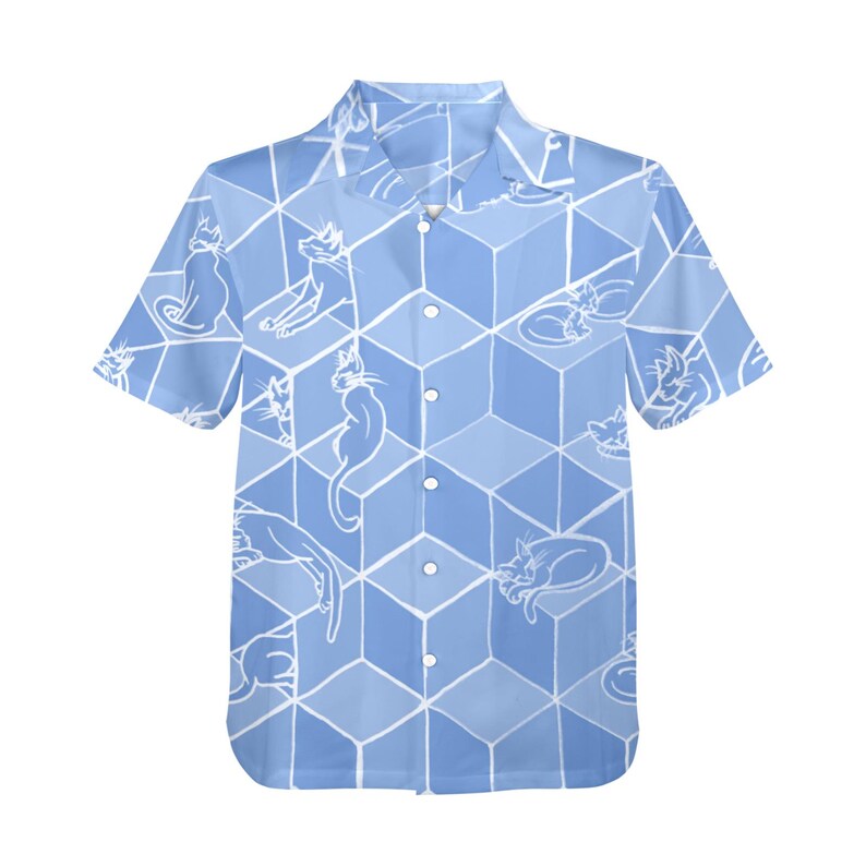 Puede incluir: Camisa azul claro de manga corta con un patr&oacute;n repetido de ilustraciones de gatos blancos sobre un dise&ntilde;o geom&eacute;trico de cubos. La camisa tiene un cuello cl&aacute;sico y cierre de botones.