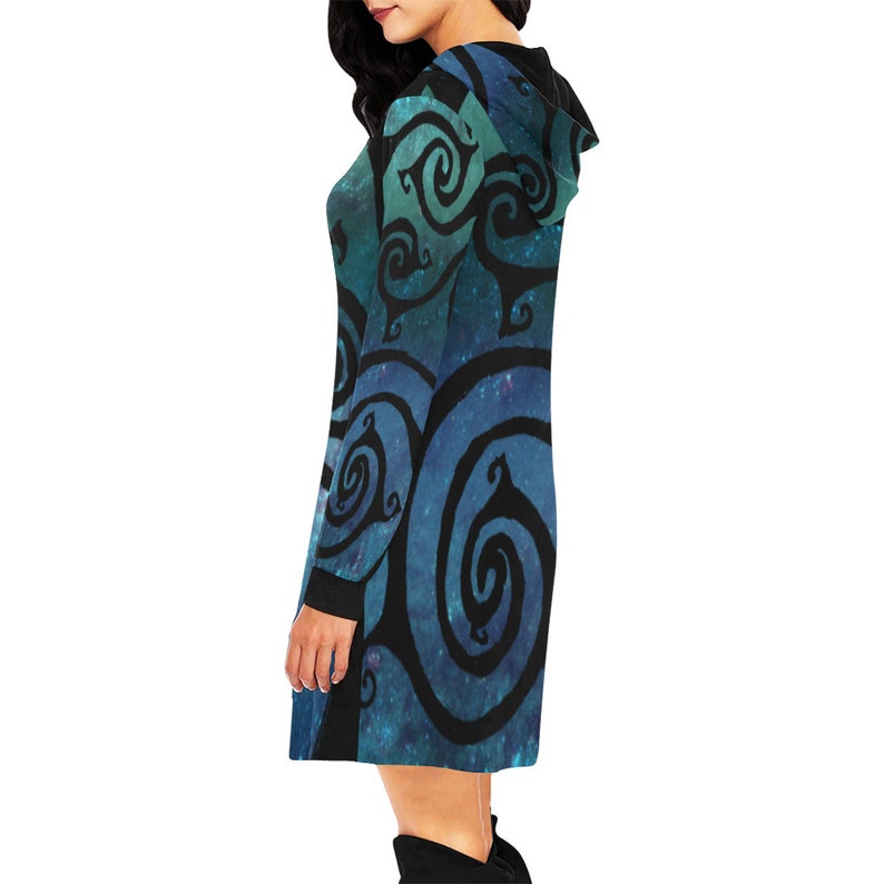 May include: A hooded dress with a blue and green galaxy print and black swirling patterns. The dress has long sleeves and a relaxed fit.