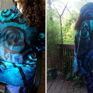 May include: A blue and black hooded sweatshirt with a swirling pattern. The sweatshirt is made of a soft, comfortable fabric and has a relaxed fit.