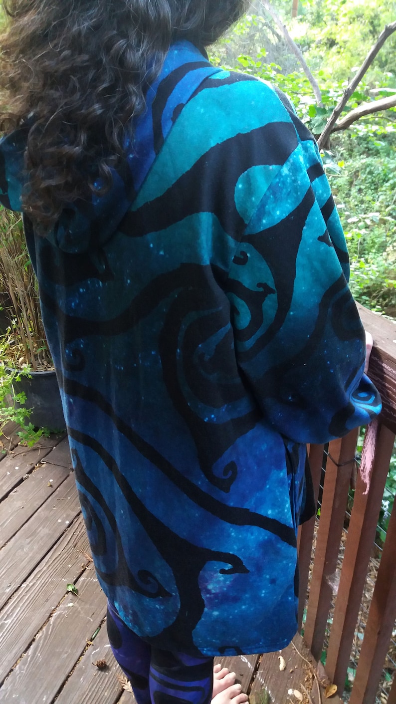 May include: A hooded jacket with a blue and black swirling pattern. The jacket is made of a soft, comfortable fabric and has a relaxed fit.