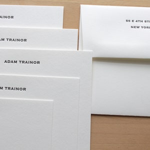 Custom letterpress cards with envelope, 118 lb text weight, neatly stacked.