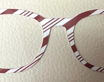 May include: Red and white striped glasses with a rounded frame. The glasses are made of a thin, flexible material.
