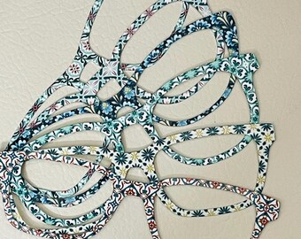 May include: A stack of colorful patterned glasses with a floral design. The glasses are made of plastic and have a retro style.