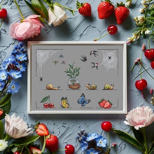 May include: A white frame containing a cross-stitch design featuring a potted plant, butterflies, snails, and birds. The frame is surrounded by strawberries, cherries, and flowers.