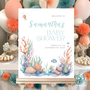 Puede incluir: Un cartel blanco con una ilustración acuarela azul de coral, algas y un pez. El texto en el cartel dice "Bienvenido a la fiesta de bienvenida al bebé de Samantha, Temecula, CA, 5 de octubre de 2024".
