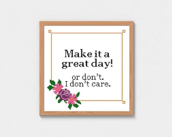 Puede incluir: Una impresión enmarcada con fondo blanco y texto negro que dice "Make it a great day! or don't. I don't care." El texto está rodeado por un marco dorado y un diseño floral en rosa y morado.