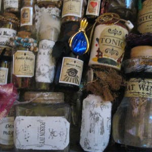 May include: A collection of small glass bottles with various labels and contents. The labels include text such as "Witch's Brew", "Tonic", "Poison Ivy", "Witches Brew", and "Bat Wing".