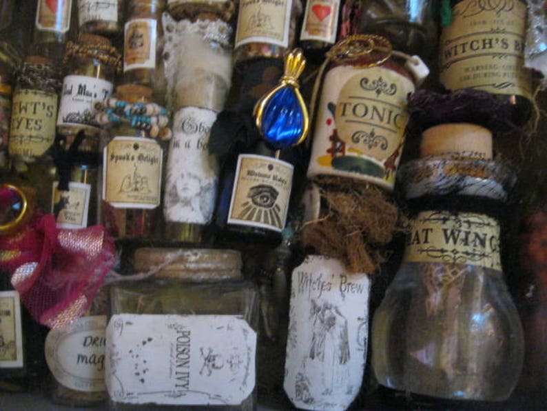 May include: A collection of small glass bottles with various labels and contents. The labels include text such as "Witch's Brew", "Tonic", "Poison Ivy", "Witches Brew", and "Bat Wing".