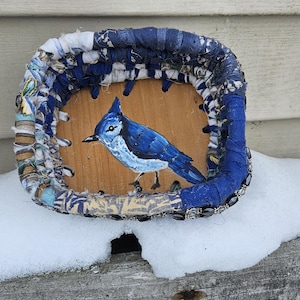 May include: Handmade wooden tray with a painted blue jay. The tray's border is crafted from fabric strips in shades of blue and cream. A unique, rustic decorative item.