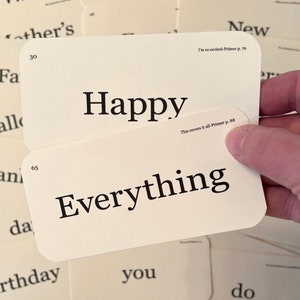 May include: Two white index cards with rounded corners. The top card has the word "Happy" printed in black. The bottom card has the word "Everything" printed in black. The text "This covers it all-Primer p. 88" is printed in black on the bottom right corner of the top card.