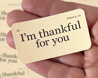 May include: A small, cream-colored card with the text "I'm thankful for you" printed in black. The card is numbered "11" and has the text "Primer p. 20" in the top right corner.