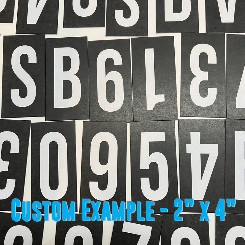 May include: Black and white letter and number stencils on a black background. The stencils are 2 inches by 4 inches. The letters and numbers are in a bold, block font. The text "CUSTOM EXAMPLE - 2" x 4" is printed at the bottom of the image.