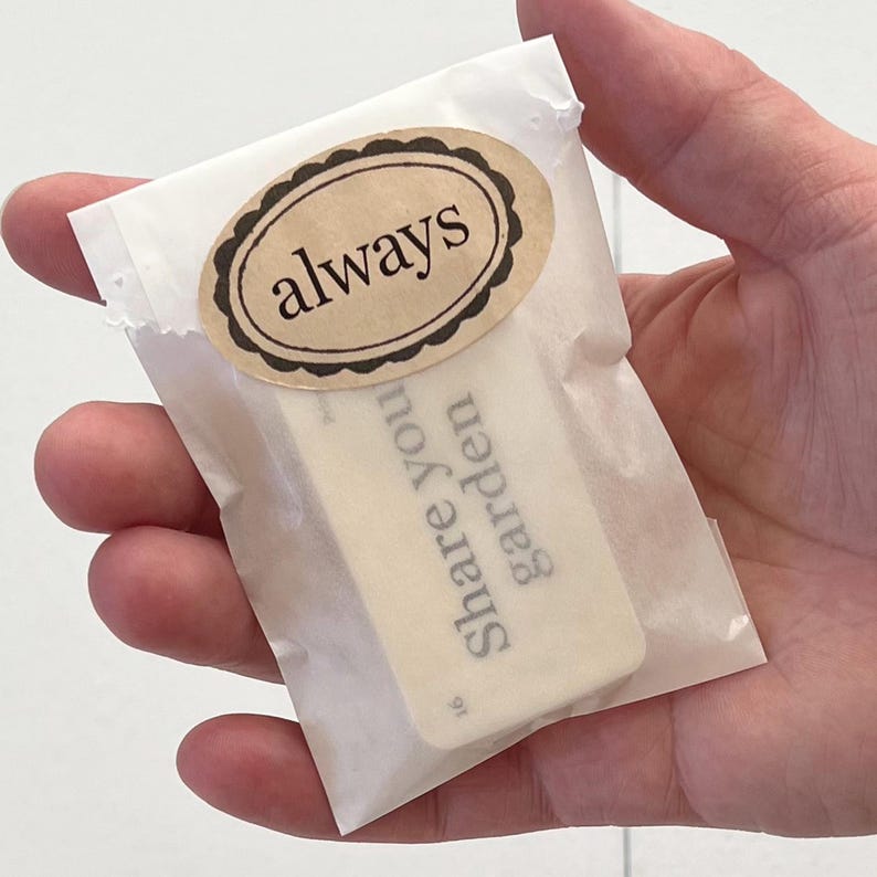 Pu&ograve; includere: Un piccolo cartoncino rettangolare bianco con la scritta "Share You Garden" stampata su di esso. Il cartoncino &egrave; in una busta di carta bianca con un adesivo ovale marrone che dice "always" in testo nero.