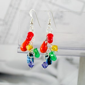 May include: Rainbow colored dangle earrings with silver hooks. The earrings feature red, orange, yellow, green, blue, and purple beads.