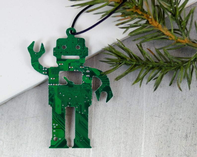 Pode incluir: Um enfeite de Natal verde em forma de rob&ocirc; feito de placa de circuito reciclada. O enfeite tem uma corda preta para pendurar.