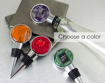 May include: Four wine bottle stoppers with different colored circuit board designs. The colors are purple, orange, red, and green. Choose a color.