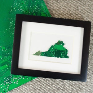May include: A framed artwork featuring the state of Virginia outlined in green circuit board material. The artwork is set against a white background and framed in black.