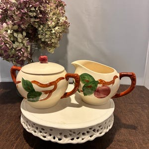 May include: A set of three ceramic mugs with a speckled, matte finish. The mugs are in shades of blue, green, and white. Each mug has a rounded shape and a simple, modern design. The mugs are suitable for coffee, tea, or other beverages.