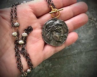 Greco-Roman Olympian inspired handmade coin pendant by Inviciti, with grey freshwater pearl tin cup chain and golden toggle clasp;