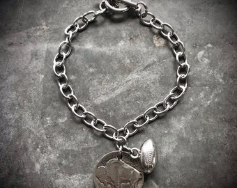 May include: A silver chain bracelet with a buffalo nickel charm and a silver football charm.