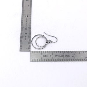 Puede incluir: Pendientes de plata de doble c&iacute;rculo con textura martillada. Los pendientes tienen un di&aacute;metro aproximado de 2,5 cm.