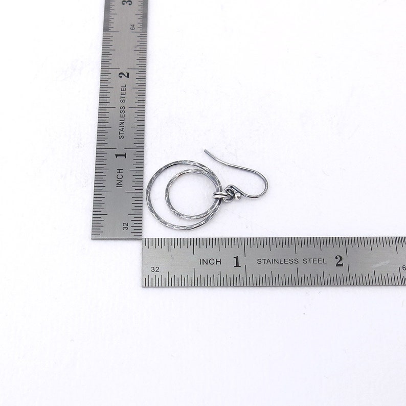 Puede incluir: Pendientes de plata de doble c&iacute;rculo con textura martillada. Los pendientes tienen un di&aacute;metro aproximado de 2,5 cm.